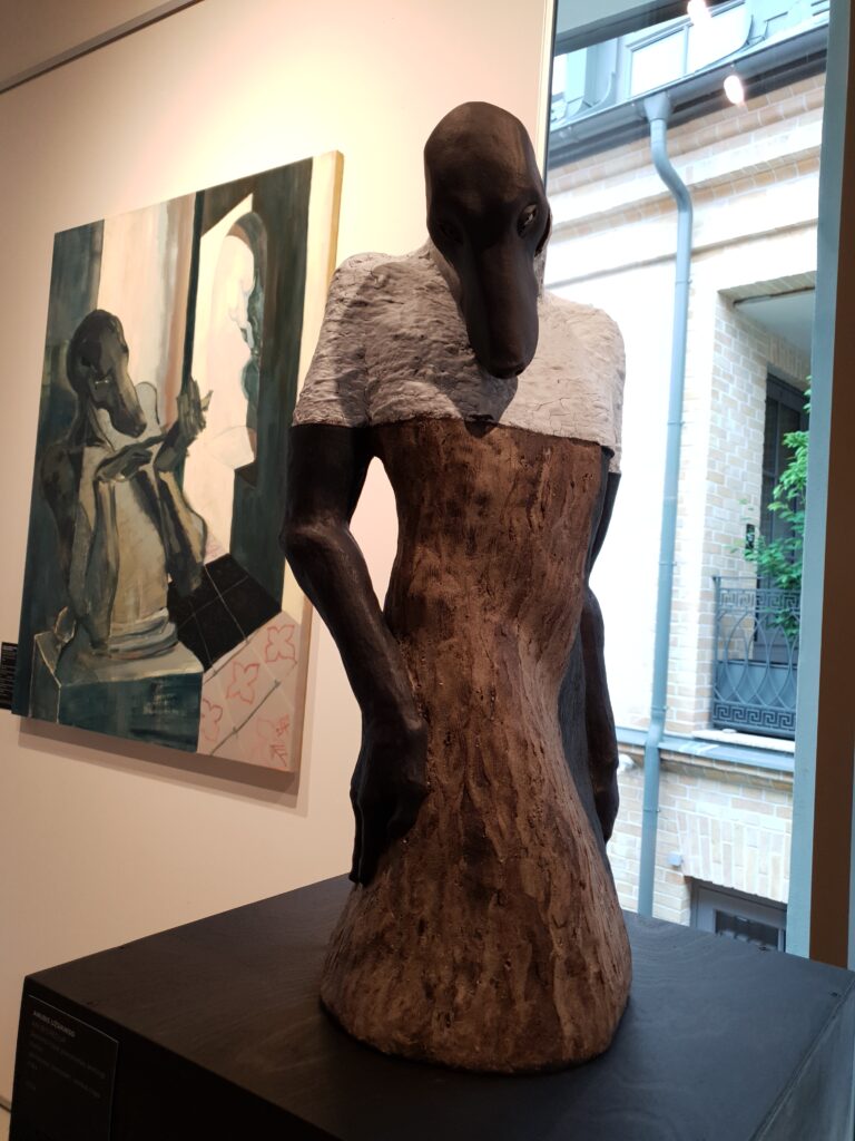 A stoneware sculpture of Anubi, a painting in the background